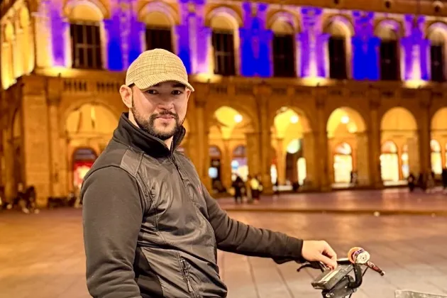 Man going by bike in Bologna by night