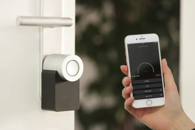 Digital lock on door and hand with a mobile phone