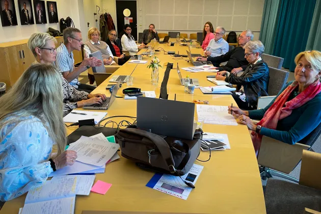Personer sitter runt ett konferensbord