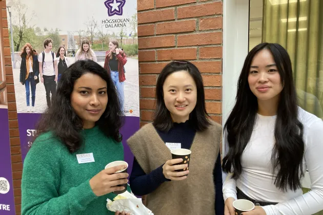 Tre kvinnor fikar i en korridor på Campus Falun.