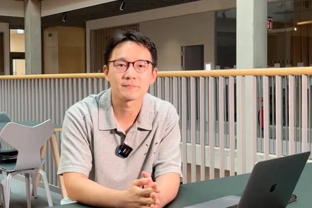 Man sitter med sin laptop vid ett bord